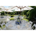 White tablecloths with white napkins and umbrella hole.