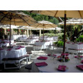 Set of white tablecloths dressing tables. There is an umbrella hole in the tablecloths.